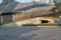 a stone building has a modern style architecture in it's centerpiece, as seen from the plaza