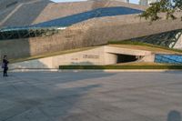 a stone building has a modern style architecture in it's centerpiece, as seen from the plaza