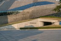 a stone building has a modern style architecture in it's centerpiece, as seen from the plaza