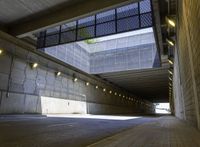 a person skates in a tunnel with a street below it underpasses light on a cloudy day