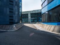 a person riding a skate board up a ramp down a sidewalk towards a building in a city