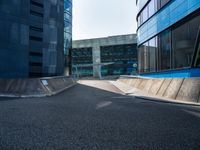 a person riding a skate board up a ramp down a sidewalk towards a building in a city