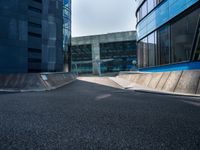 a person riding a skate board up a ramp down a sidewalk towards a building in a city