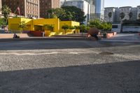 a man skateboarding near some yellow buildings on a sunny day in the city with people