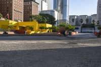 a man skateboarding near some yellow buildings on a sunny day in the city with people