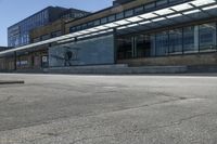 a person riding a skateboard on top of a sidewalk next to a train station