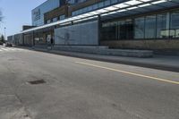 a person riding a skateboard on top of a sidewalk next to a train station