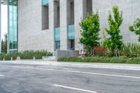 a man riding a skateboard in the street next to a tall building next to a street