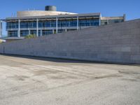 a man skateboards down the concrete steps and a building in the background from an urban parking lot