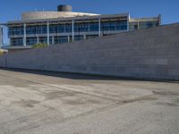 a man skateboards down the concrete steps and a building in the background from an urban parking lot