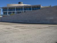 a man skateboards down the concrete steps and a building in the background from an urban parking lot