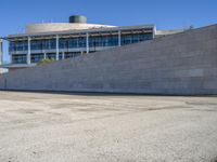 a man skateboards down the concrete steps and a building in the background from an urban parking lot