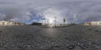 this is a fisheye lens photo of a person riding his skateboard on an empty street