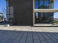 a person with a skateboard near some windows and a building under a clear blue sky