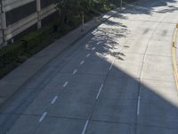 a person riding a skateboard on a sidewalk next to a tall building and trees