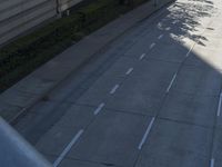 a person riding a skateboard on a sidewalk next to a tall building and trees