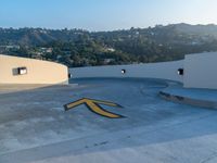 a man is standing on a skateboard on the edge of a roof with a big arrow painted in the concrete