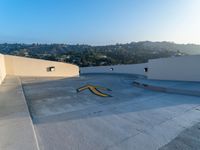 a man is standing on a skateboard on the edge of a roof with a big arrow painted in the concrete