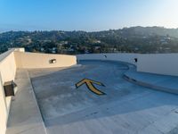 a man is standing on a skateboard on the edge of a roof with a big arrow painted in the concrete