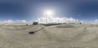 a man is riding his skateboard at the top of a ramp by buildings and a sun