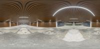 a skateboarder has his board at the top of a ramp in an underground garage