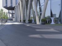 the man is riding his skateboard near the modern building's entrance, near other modern buildings