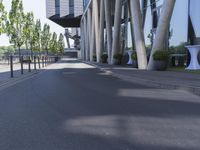 the man is riding his skateboard near the modern building's entrance, near other modern buildings