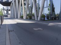 the man is riding his skateboard near the modern building's entrance, near other modern buildings