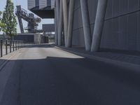 the man is riding his skateboard near the modern building's entrance, near other modern buildings