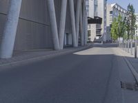 the man is riding his skateboard near the modern building's entrance, near other modern buildings