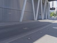 the man is riding his skateboard near the modern building's entrance, near other modern buildings