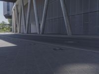 the man is riding his skateboard near the modern building's entrance, near other modern buildings