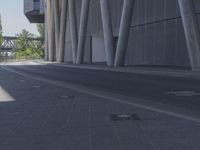 the man is riding his skateboard near the modern building's entrance, near other modern buildings