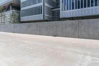 a skateboarder rides a skate board down an empty concrete street near a high - rise office building