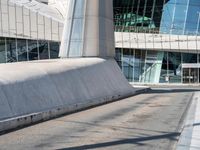 a man is skateboarding on a paved walkway near some modern buildings at an angle