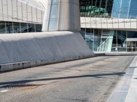 a man is skateboarding on a paved walkway near some modern buildings at an angle