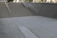 a boy is skateboarding down a concrete sidewalk by stairs and trees outside an office building