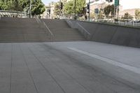 a boy is skateboarding down a concrete sidewalk by stairs and trees outside an office building