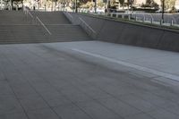 a boy is skateboarding down a concrete sidewalk by stairs and trees outside an office building