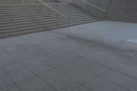 a boy is skateboarding down a concrete sidewalk by stairs and trees outside an office building