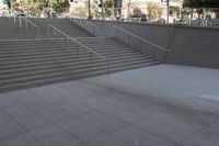 a boy is skateboarding down a concrete sidewalk by stairs and trees outside an office building