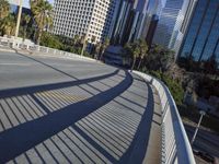 a skateboarder is riding along the empty city street in front of the skyscrapers