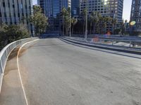 a skateboarder is riding along the empty city street in front of the skyscrapers