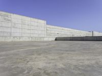 a person on a skateboard rides in the middle of an empty cement ramped area