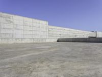 a person on a skateboard rides in the middle of an empty cement ramped area