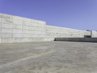 a person on a skateboard rides in the middle of an empty cement ramped area