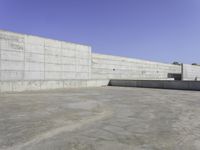 a person on a skateboard rides in the middle of an empty cement ramped area