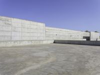 a person on a skateboard rides in the middle of an empty cement ramped area