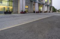 a person riding a skateboard on a street near a building in the evening with clouds