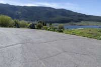 a man riding a skateboard on top of a paved surface near mountains and trees